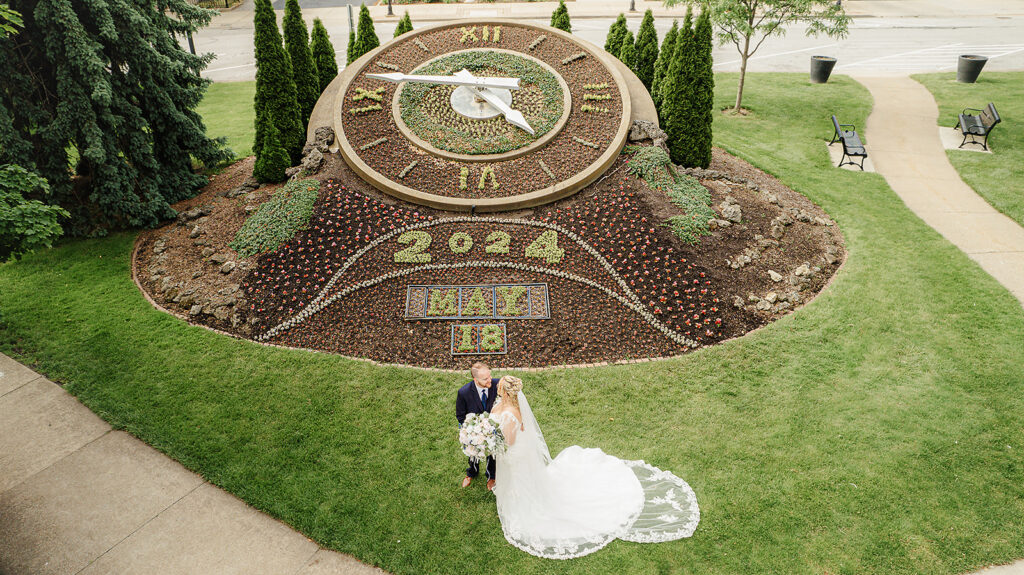 Drone shot of bride and groom infront of clock in downtown sandusky