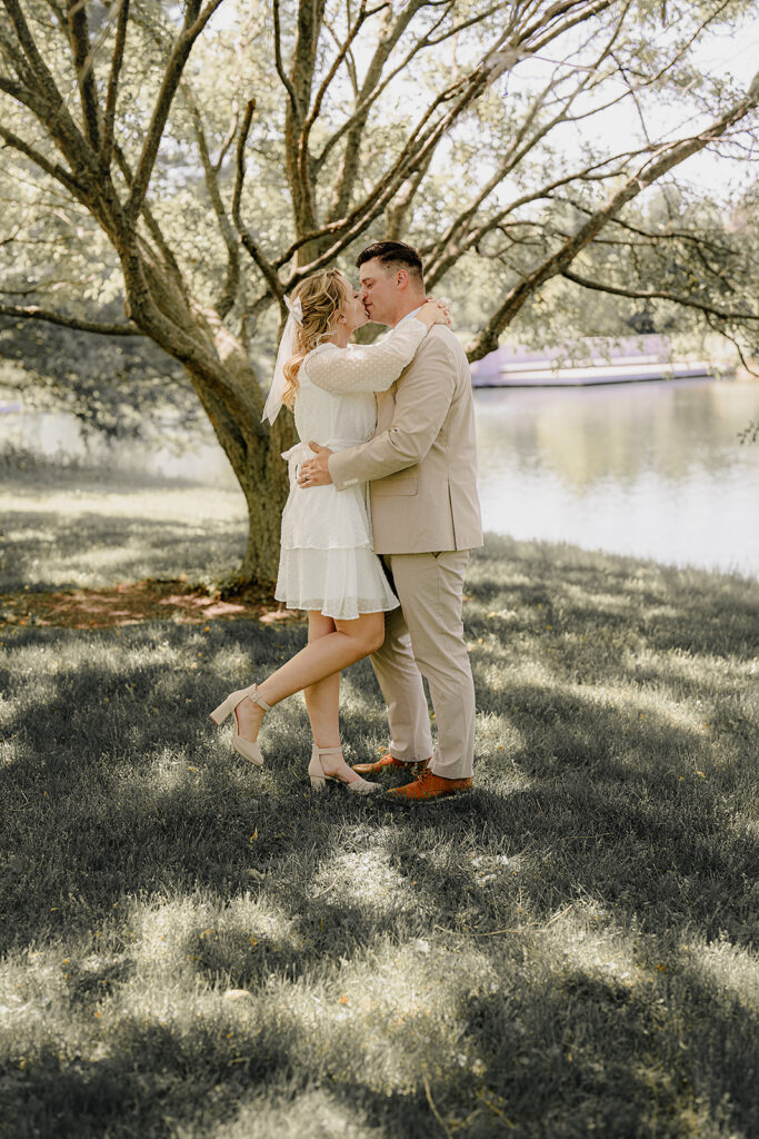 bride and groom kissing leg pop