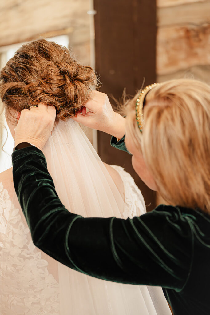 mother of the bride putting in the brides veil 