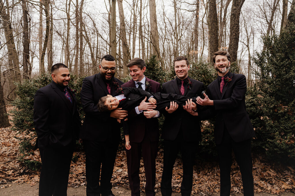 group picture of all the groomsman holding the grooms son