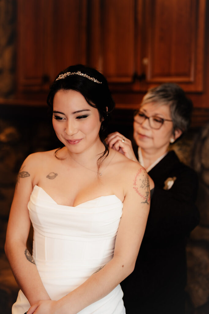 shot of the brides mother putting on a necklace